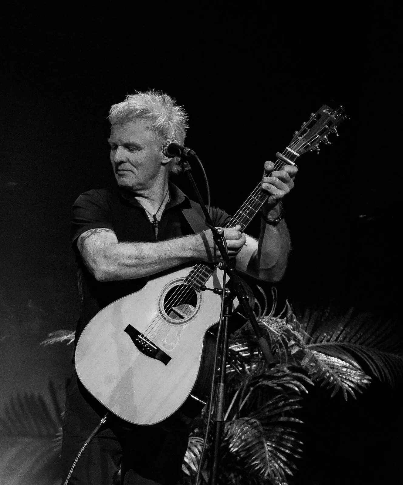 Jeff Zwart speelt akoestische gitaar tijdens een optreden